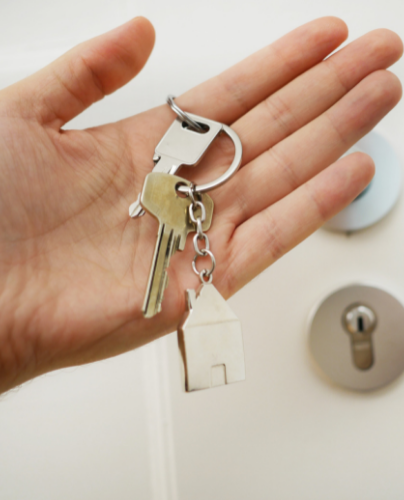 A hand holding some keys with a house keyring